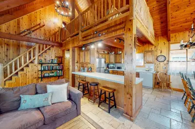 a living room and kitchen in a log cabin at Tahoe Pines Cabin in Homewood