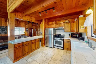 a kitchen with wooden cabinets and a stainless steel refrigerator at Tahoe Pines Cabin in Homewood