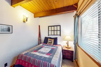 a bedroom with a bed and a lamp on a table at Tahoe Pines Cabin in Homewood
