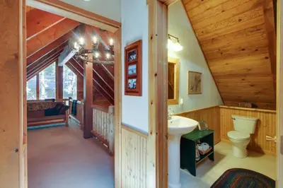a bathroom with a toilet and a sink in a house at Tahoe Pines Cabin in Homewood