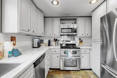 a kitchen with white cabinets and stainless steel appliances at Muhlebach Haven in Truckee