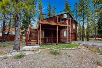 a log cabin in the woods with a tree at Muhlebach Haven in Truckee