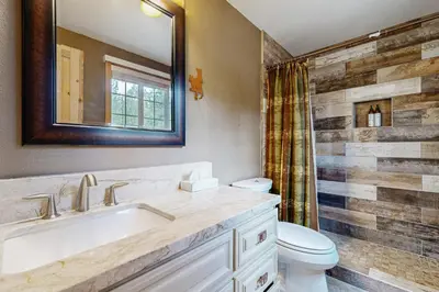 a bathroom with a sink and a toilet and a mirror at Muhlebach Haven in Truckee