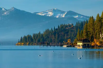 a large lake with a house and trees and mountains at Carnelian Bay Paradise in Carnelian Bay