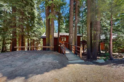 a cabin in the middle of a forest with a wooden bridge at Simplon Pass Escape in Homewood