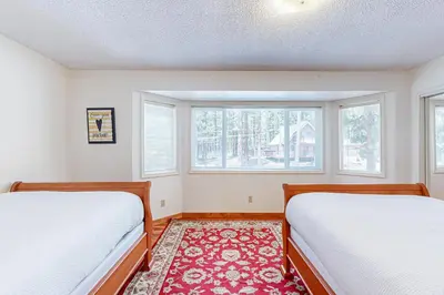 two beds in a room with two windows at Lone Indian Charms in South Lake Tahoe