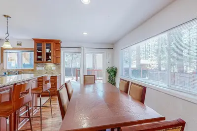 a kitchen with a wooden table and a large window at Lone Indian Charms in South Lake Tahoe