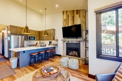 a kitchen and living room with a fireplace at Ski-In, Ski-Out Designer Condo in Truckee
