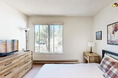 a bedroom with a bed and a tv and a window at Ski Bowl Condos Unit 518 in Truckee