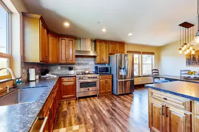 a kitchen with wooden cabinets and stainless steel appliances at Pooewin Place in South Lake Tahoe