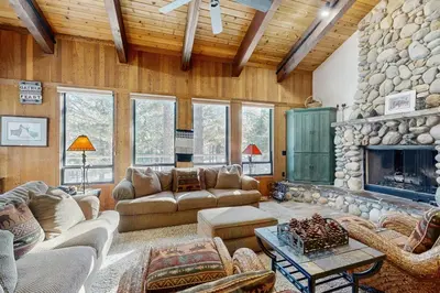 a living room with couches and a stone fireplace at Northstar Home in Truckee