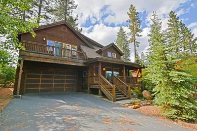 a large house with a garage in the woods at Kimque Dreams in Truckee