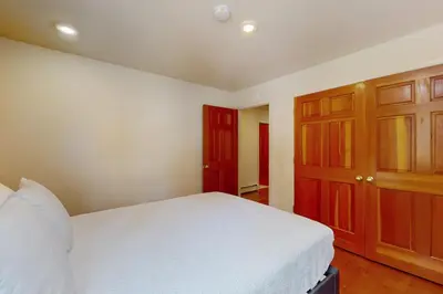 a bedroom with a white bed and wooden cabinets at High Meadow Storybook in South Lake Tahoe