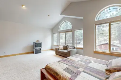 a bedroom with a bed and a couch and windows at Charles Charmer in South Lake Tahoe
