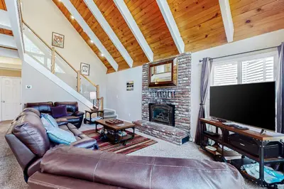 a living room with a large television and a fireplace at Montgomery Estates Retreat in South Lake Tahoe