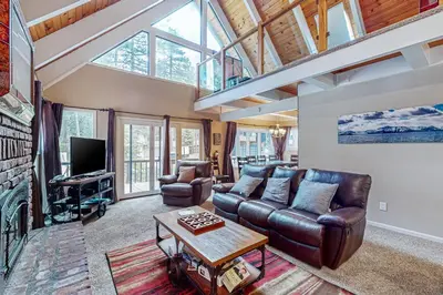 a living room with a leather couch and a tv at Montgomery Estates Retreat in South Lake Tahoe