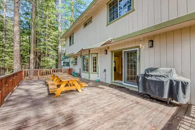 a wooden deck with a picnic table next to a house at Montgomery Estates Ski & Beach Haven in South Lake Tahoe
