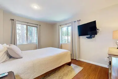 a bedroom with a bed and a flat screen tv at Cellador Charms in South Lake Tahoe