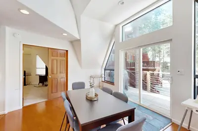a dining room with a table and chairs and a large window at Chamonix Escape in Truckee