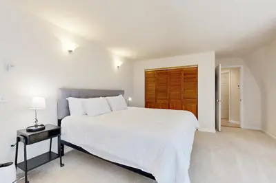 a bedroom with a white bed and a wooden door at Chamonix Escape in Truckee