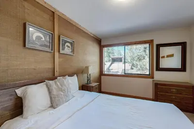 a bedroom with a white bed and a window at Rocky Point Charms in Truckee