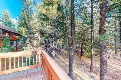a wooden balcony with a view of the woods at The Bear's Lair House in Truckee