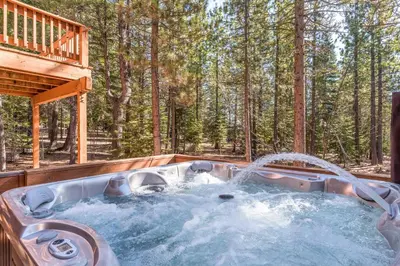 a hot tub in the middle of a forest at The Bear's Lair House in Truckee