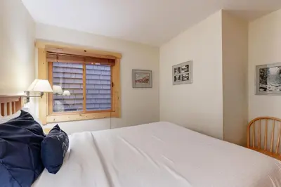 a bedroom with a white bed and a window at Slopeside Adventures in Truckee
