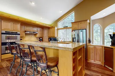 a kitchen with wooden cabinets and a island with bar stools at Cochise Adventures in South Lake Tahoe