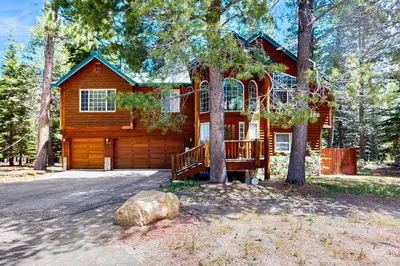 a log cabin with a porch and a driveway at Cochise Adventures in South Lake Tahoe