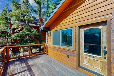 a wooden cabin with a large door on a deck at Spectacular Lakeview Cabin in Kings Beach