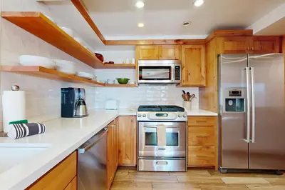 a kitchen with wooden cabinets and stainless steel appliances at Spectacular Lakeview Cabin in Kings Beach