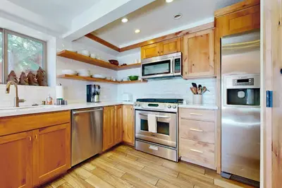 a kitchen with wooden cabinets and stainless steel appliances at Spectacular Lakeview Cabin in Kings Beach