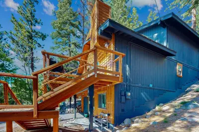 a wooden staircase leading up to a blue house at Spectacular Lakeview Cabin in Kings Beach