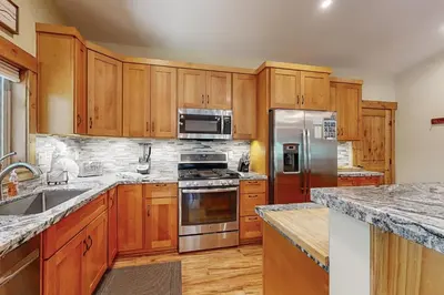 a kitchen with wooden cabinets and stainless steel appliances at Thunderbird Palace in South Lake Tahoe