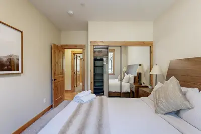 a bedroom with a white bed and a mirror at Thunderbird Palace in South Lake Tahoe