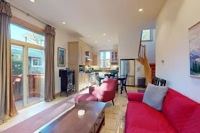 a living room with a red couch and a table at Cottage Charms in South Lake Tahoe