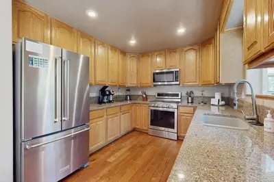 a kitchen with wooden cabinets and a stainless steel refrigerator at Backyard Oasis in South Lake Tahoe