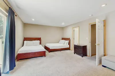 a bedroom with two beds and a couch and a window at Backyard Oasis in South Lake Tahoe