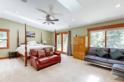 a bedroom with a bed and two leather chairs at Cherry Hill Charms in South Lake Tahoe