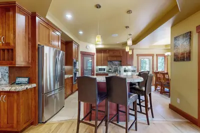 a kitchen with a table with chairs and a refrigerator at Cherry Hill Charms in South Lake Tahoe