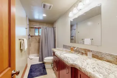 a bathroom with a sink and a toilet and a mirror at Cherry Hill Charms in South Lake Tahoe