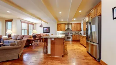 a kitchen and living room with a stainless steel refrigerator at Snowcreek VI The Lodges #1133 condo in Mammoth Lakes
