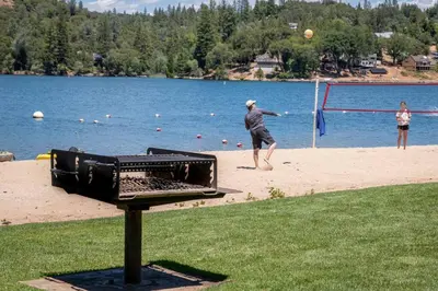 a man playing a game of volley ball on the beach at New Luxury 5BR Cabin in Pine Mountain Lake! 1 Minute to Beach! Massage Chair! Close to Yosemite! Perfect for Retreats and Escapes All Seasons! in Groveland