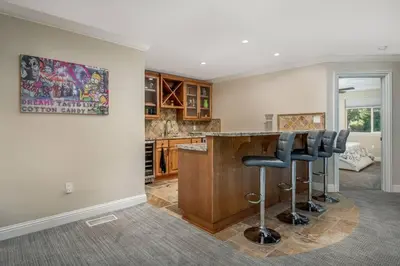 a kitchen with a bar with stools in a room at New Luxury 5BR Cabin in Pine Mountain Lake! 1 Minute to Beach! Massage Chair! Close to Yosemite! Perfect for Retreats and Escapes All Seasons! in Groveland