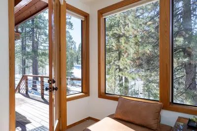 a living room with windows and a couch at Creekside at Northstar home in Truckee
