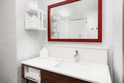 a bathroom with a white sink and a red mirror at Hampton Inn Oakhurst-Yosemite in Oakhurst