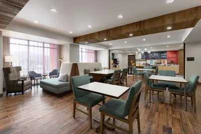 a dining room with tables and chairs and a kitchen at Hampton Inn Oakhurst-Yosemite in Oakhurst