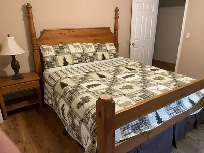 a bed with a quilt on it in a bedroom at Cozy Cabin in Arnold ! in Arnold
