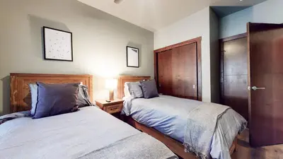a bedroom with two beds and a night stand with a lamp at Solstice #14 condo in Mammoth Lakes